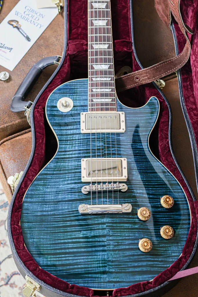 Gibson Les Paul Standard electric guitar in translucent blue finish inside a hardshell case with original Gibson Gold Warranty booklet.